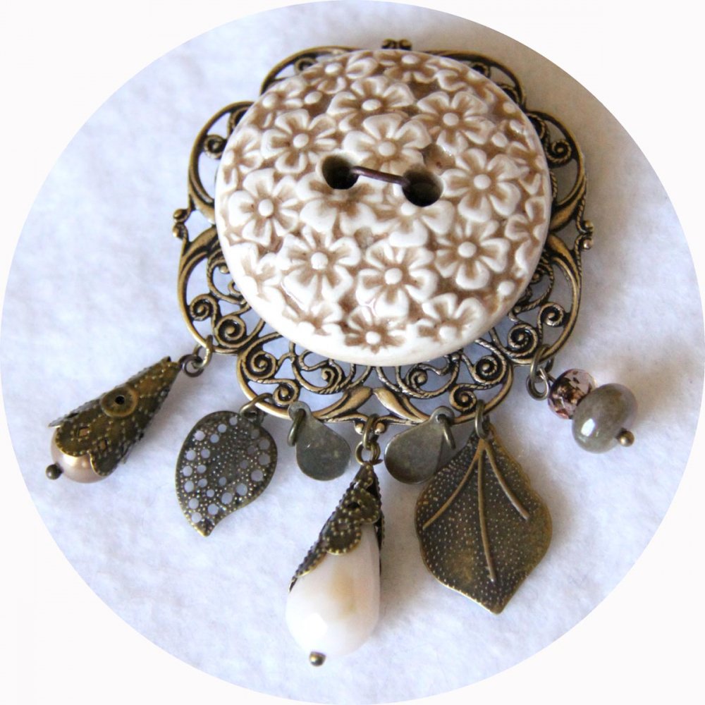 Broche ronde bouton en céramique beige et ivoire sur fond filigrané bronze avec breloques bronze et perles crème--9995968857241