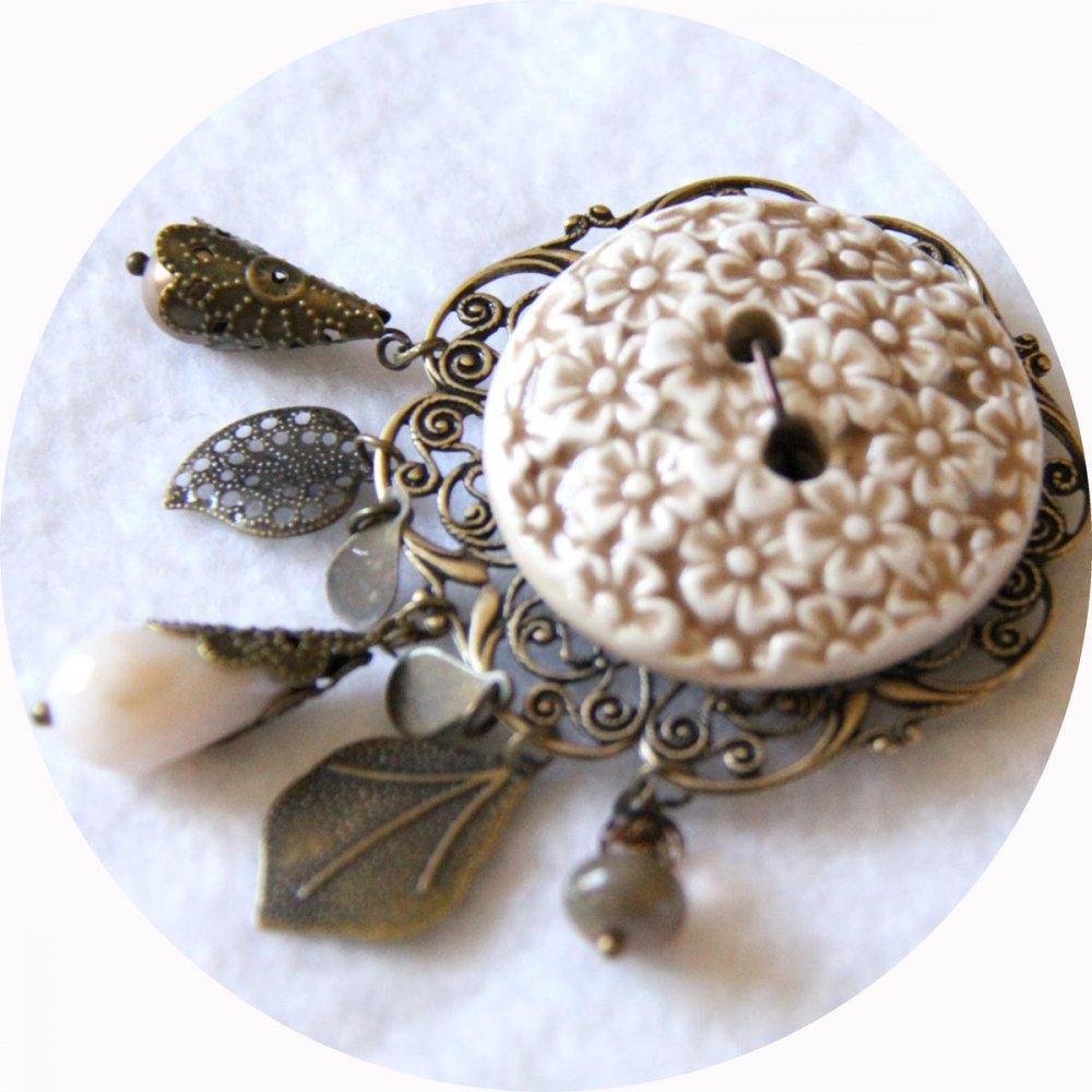 Broche ronde bouton en céramique beige et ivoire sur fond filigrané bronze avec breloques bronze et perles crème--9995968857241