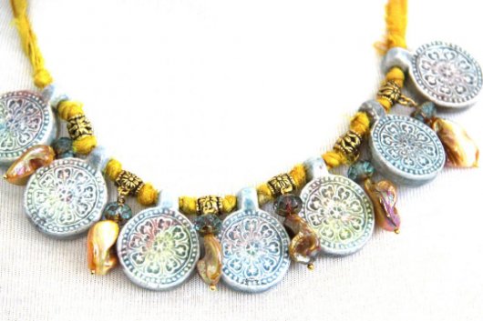 Collier en raku bleu et jaune avec des médaillons style mandala en céramique bleus et des perles de nacre jaune sur cordon de soie jaune