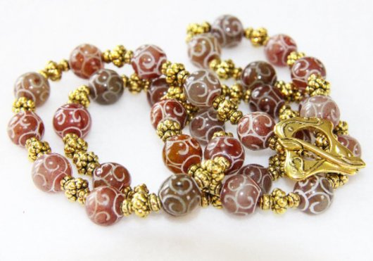 Collier sautoir rouge et or en perles d'agate rouge bordeaux gravées et perles dorées