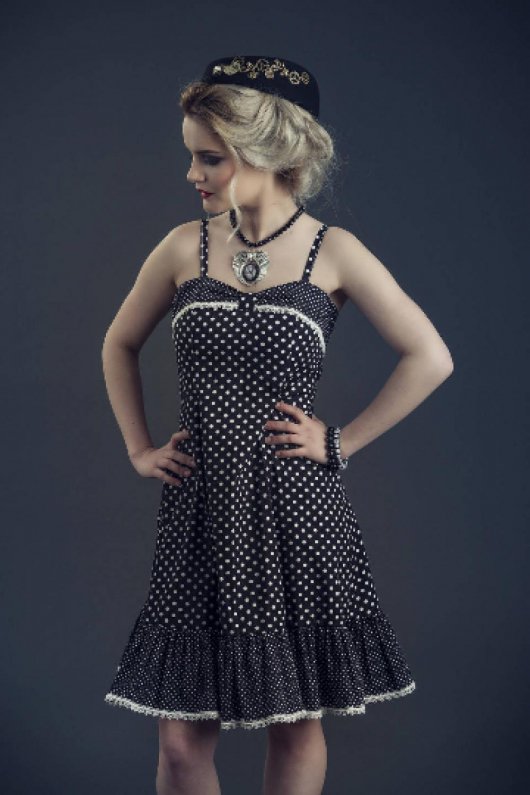 Robe Pin-Up d'inspiration années 50 en coton noire à pois blancs et dentelle blanche ajustée sur le buste avec une jupe évasée