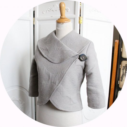 Veste courte en tissu matelassé gris clair à grand col chale et manches trois quart