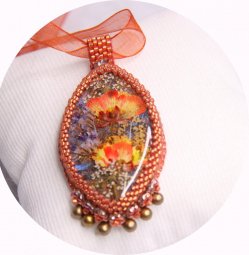 Collier médaillon fleurs séchées orange et jaune serti de perles japonaises et cristal